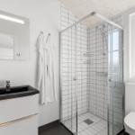 Badezimmer mit Dusche, Waschbecken und Toilette.