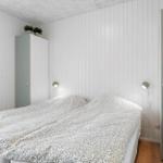 Schlafzimmer mit Bett, Kleiderschrank und Wandlampen.