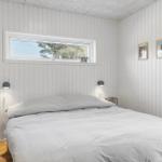 Schlafzimmer mit Bett, Fenster und Wandbildern.