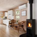 Küche mit Essbereich und Kaminofen. Holzwände und -boden.