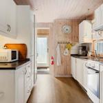 Küche mit weißen Schränken, dunklen Arbeitsflächen und Holzfußboden.
