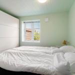 Schlafzimmer mit Bett, Fenster und Schrank. Decke mit Holzverkleidung.
