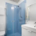 Badezimmer mit Dusche, Waschbecken und Toilette.