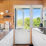 Küche mit Holzwand, Fenster und weißen Schränken