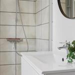 Badezimmer mit Dusche, Waschbecken und Spiegel