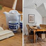 Holztisch mit Teekanne und Buch in einem Raum mit schrägem Dach und Wickerstühlen.