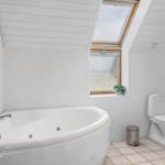 Badezimmer mit Whirlpool, Toilette und Dachfenster