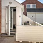 Haus mit Terrasse, offener Eingang und Gartenbereich