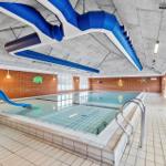 Indoor-Schwimmbad mit blauer Rutsche und kinderfreundlichen Wanddekorationen.
