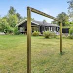 Schwarzes Haus mit großem Garten und Liegeflächen im Freien.