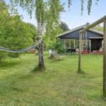 Haus mit Garten, Hängematten und Schaukel. Grünflächen und Bäume umgeben die Terrasse.