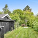 Haus mit grünem Garten und Basketballkorb im Hintergrund.