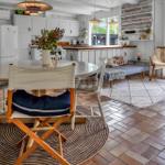 Ein Essbereich mit Tisch und Stühlen, Küche und Sitzgelegenheit im Hintergrund.