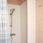 Dusche mit Duschvorhang und Handbrause in Holzbadezimmer
