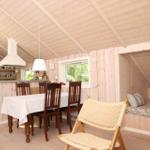 Küche mit Esstisch, Schlafgelegenheit und Fenster.