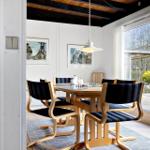 Esszimmer mit Holztisch, Stühlen und Fensterblick auf Garten