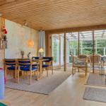 Wohnraum mit Essbereich, Holzdecke und Blick auf Terrasse.