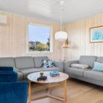 Wohnzimmer mit grauem Sofa, blauem Sessel und runden Tisch.