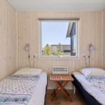 Zwei Einzelbetten mit Tisch und Fenster im Schlafzimmer.