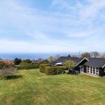 Schwarzes Haus mit Garten und Meerblick. Grünflächen und Bäume umgeben die Unterkunft.