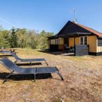 Haus mit Terrasse, Liegestühlen und Picknicktisch im Grünen.
