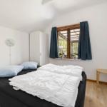 Schlafzimmer mit Bett, Fenster und Kleiderschrank.