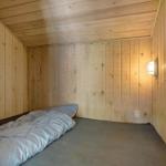 Ein Schlafzimmer mit Holzwänden und einem Bett mit Bettwäsche.