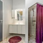Badezimmer mit Dusche, Waschbecken und Spiegel