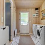 Wohnung mit Waschmaschine und Trockner, Holzwand und Fliesenboden.