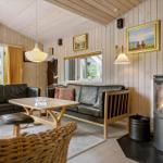 Wohnzimmer mit Holzwand, Sofa, Kamin und Tisch