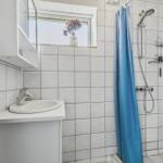 Bathroom with shower, sink, and window