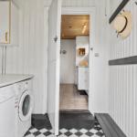 Apartment with washing machine, shoe rack, and view into the kitchen.