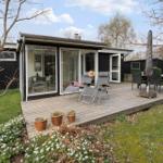 Modern vacation home with terrace, sun loungers, and garden.