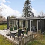 Modern villa with terrace, grill area, and garden. Living area with glass wall.