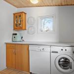 Wohnung mit Waschmaschine und Spülmaschine, Holzdecke und Fenster.