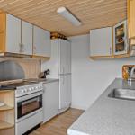 Küche mit Arbeitsplatte, Spüle, Kühlschrank und Herd.