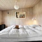 Schlafzimmer mit Holzwand, Bett und Fenster.