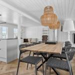 Essbereich mit Holztisch und Stühlen, Küche mit Arbeitsplatte und Fenster