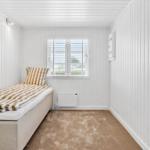 Schlafzimmer mit Bett, Fenster und Heizung.