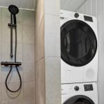 Dusche mit Duschbrause und Waschmaschine-Trocknerkombination