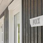 Haus mit Holzfassade und Schild FOIX an der Wand