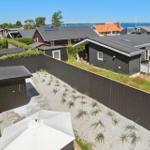 Modernes Ferienhaus mit Terrasse und Garten. Blick auf Meer und Nachbarhäuser.