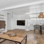 Wohn- und Essbereich mit Holzboden, Fernseher und Esstisch.