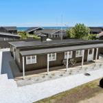Moderne Ferienhaus mit Terrasse, Blick auf Meer und Nachbarhäuser.