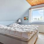 Schlafzimmer mit Dachschrägen, Fenster und Bett.