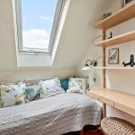 Dachgeschosszimmer mit Dachfenster, Bett und Schreibtisch.