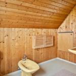 Bad mit Holzwand, Bidet, Waschbecken und Dusche