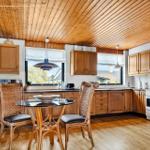 Küche mit Holzdecke, Essbereich und blauen Teller an der Wand.