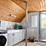 Küche mit Waschmaschine, Spüle und Tür zum Garten.