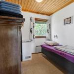 Ein Schlafzimmer mit Bett, Schrank, Fenster und Klimagerät.